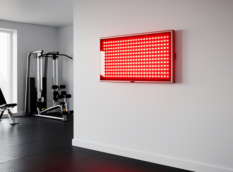 Standalone wall-mounted red light therapy panel in a home gym with no sauna nearby
