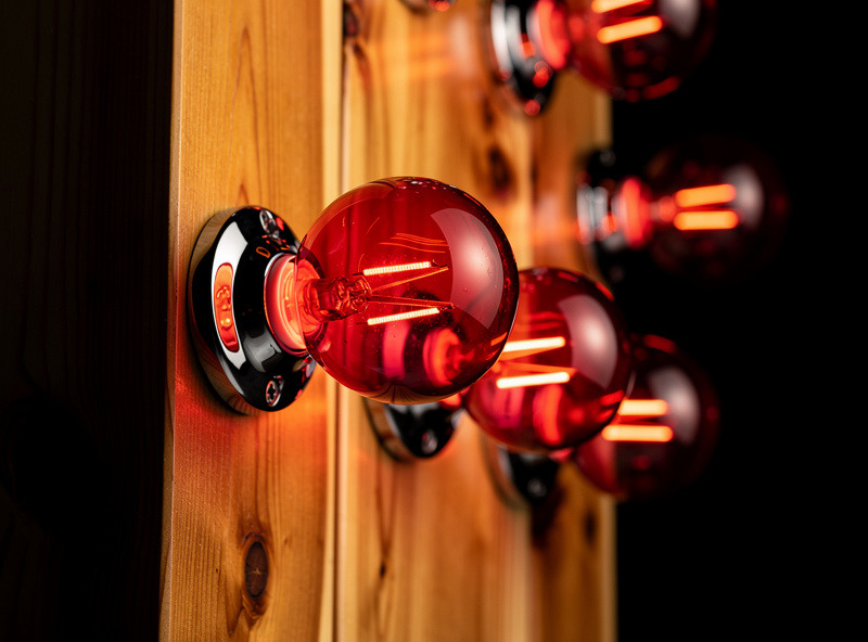 SaunaSpace style cabin with incandescent ThermaLight NIR bulbs visible glowing inside cedar interior