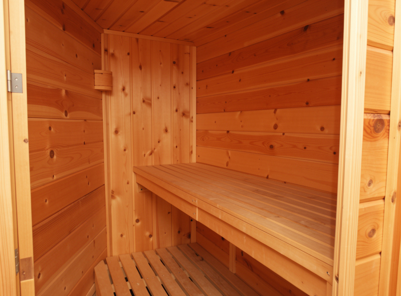 Interior of a framed sauna room being lined with tongue-and-groove hemlock boards