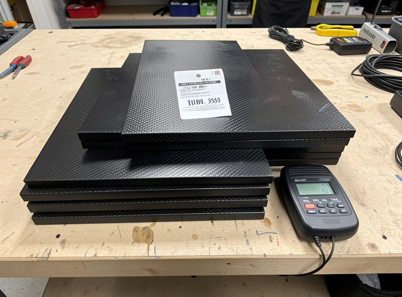 Carbon-fiber infrared heater panels stacked with a price tag and a kill-a-watt energy meter