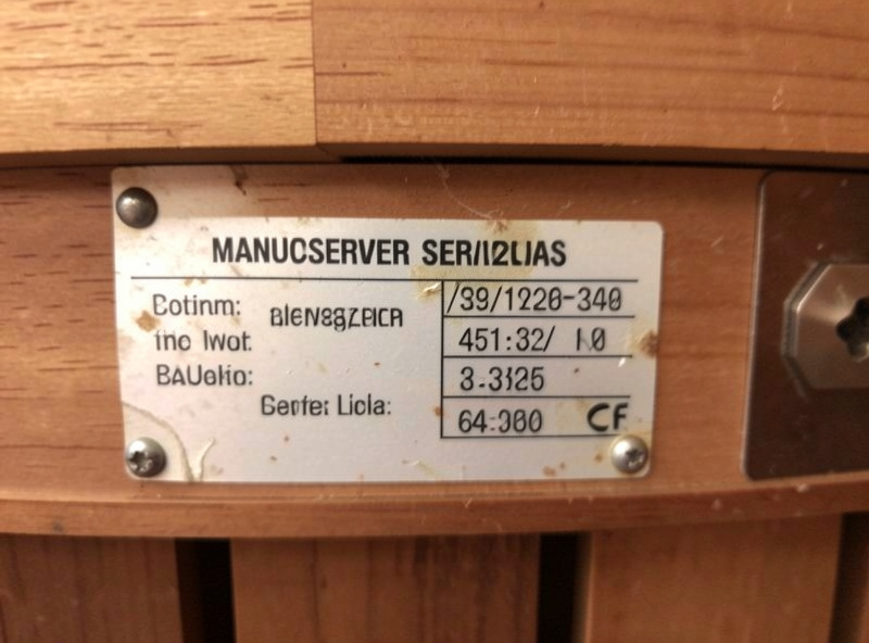 A manufacture date and serial number sticker on the back of an older infrared sauna cabin