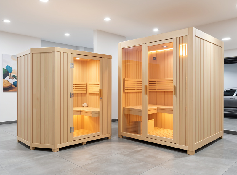 Two infrared sauna cabins of different sizes side by side in a showroom showing the price gap