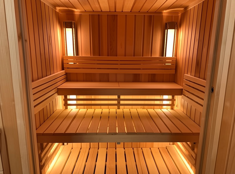 Diagram-style view of an infrared sauna interior showing heater panel positions around the bench, back, sides and floor for full radiant coverage