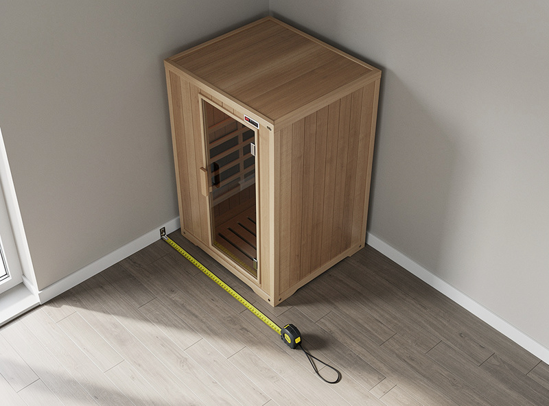 Infrared sauna cabin in a room corner with a tape measure showing clearance from the wall on vinyl plank flooring