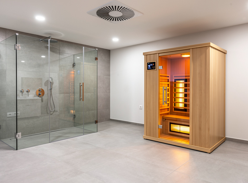 Infrared sauna installed in a spacious modern bathroom with tile floor and ceiling exhaust fan