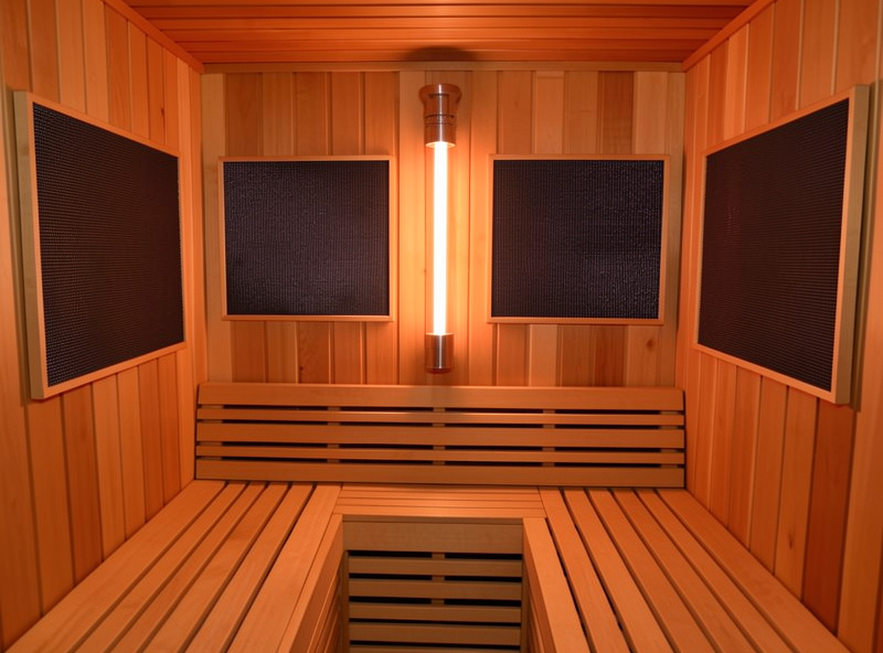 Full-spectrum infrared sauna interior with far-infrared carbon panels and a front-mounted near-infrared emitter