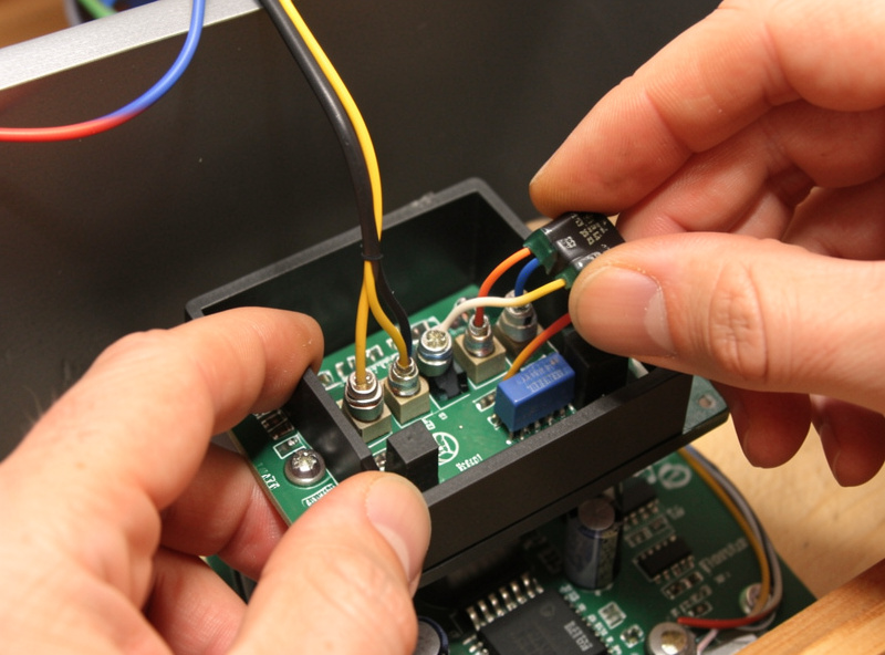Hands wiring the heater output terminals of a replacement infrared sauna controller