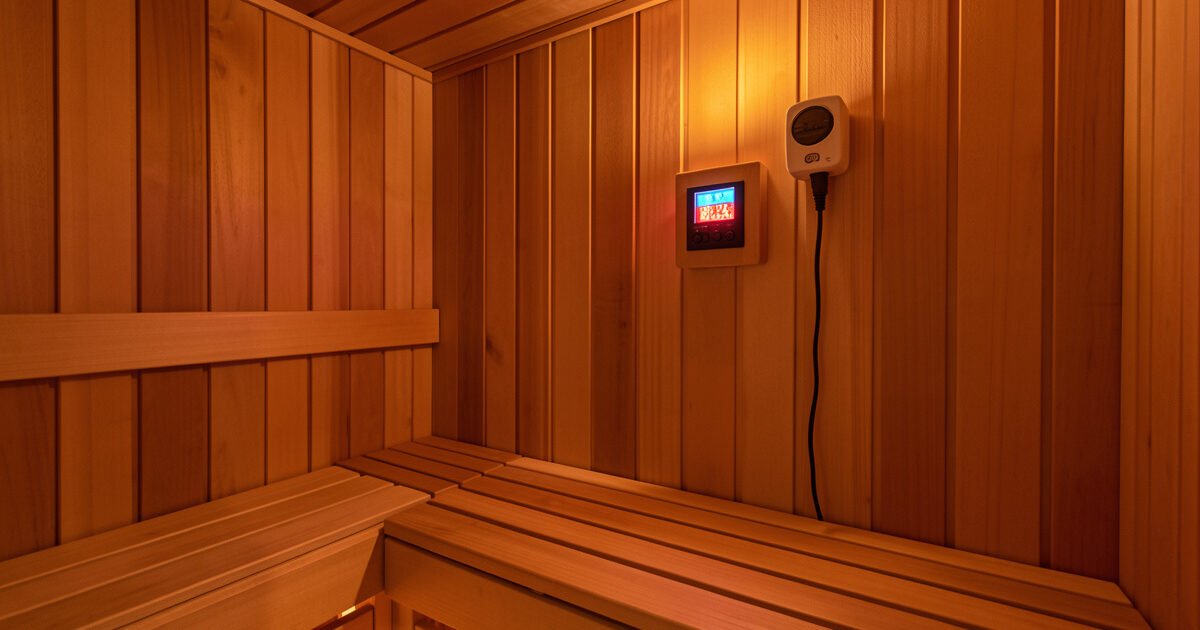 High-temperature thermostat and probe mounted at bench height in a sauna