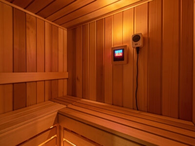 High-temperature thermostat and probe mounted at bench height in a sauna