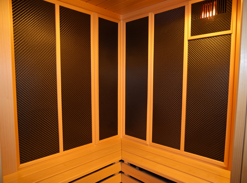 Close-up of carbon heater panels covering the back wall of an infrared sauna cabin
