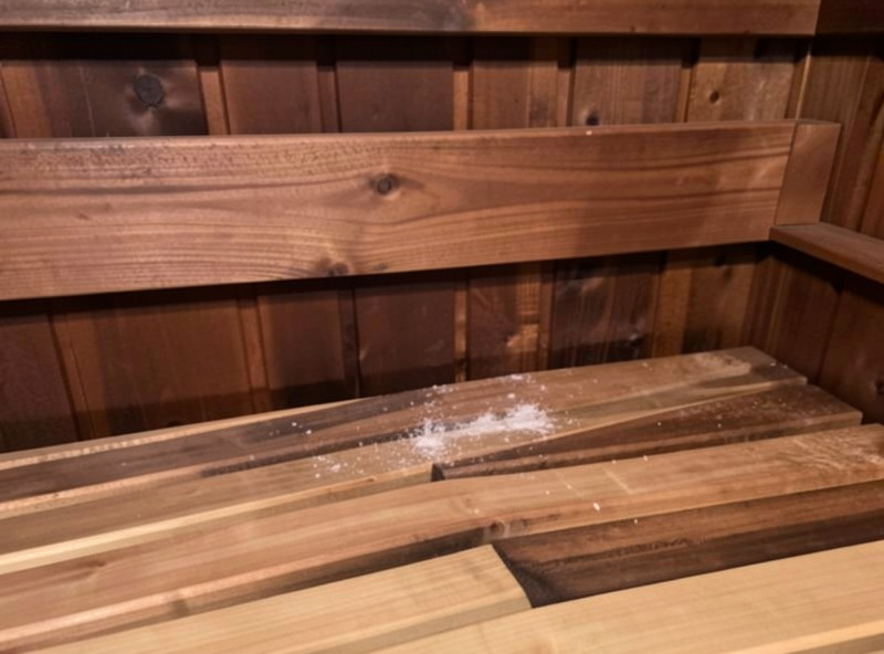 Slightly darkened hemlock wood behind a sauna backrest where odor tends to collect