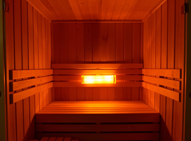 Near-infrared halogen emitter glowing in a full-spectrum infrared sauna cabin