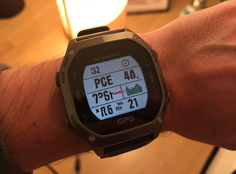 GPS running watch on a wrist showing pace and heart-rate data