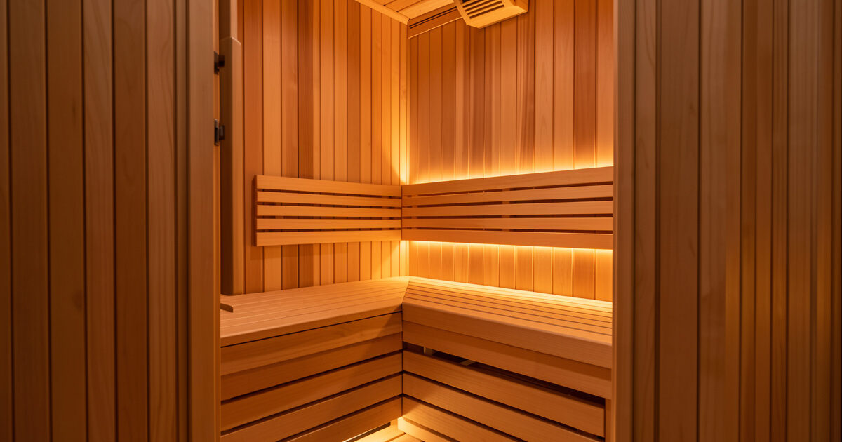 Infrared sauna cabin interior with a supportive hemlock bench and soft warm ambient light