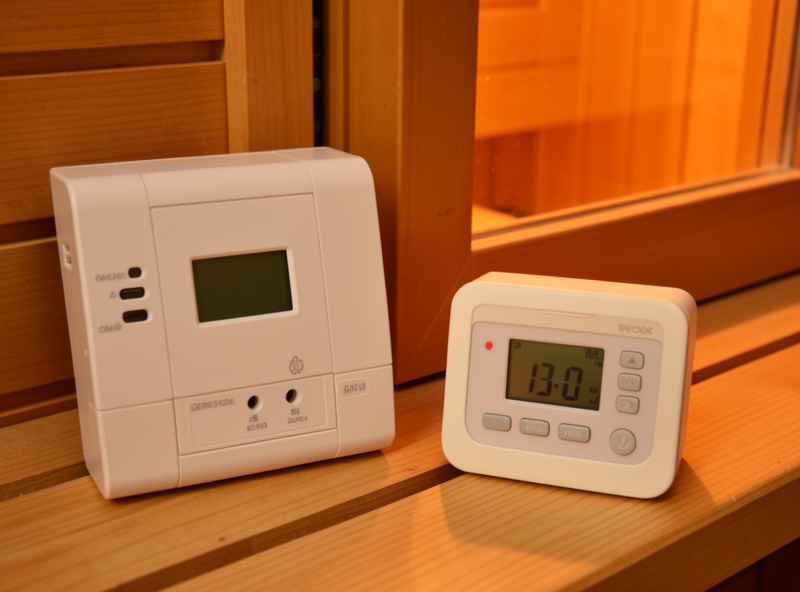 Plug-in energy meter and digital hygrometer beside an infrared sauna door