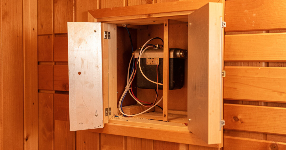 Infrared sauna heater panel removed from the wall showing the element and wiring behind it