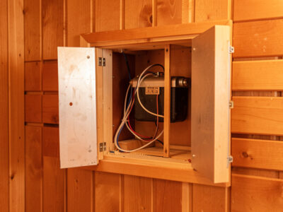 Infrared sauna heater panel removed from the wall showing the element and wiring behind it