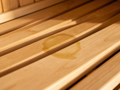 Faint yellow-brown sweat stain shadow on a hemlock infrared sauna bench