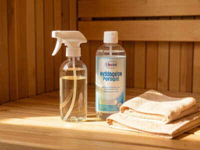 Sauna cleaning supplies: diluted vinegar spray, hydrogen peroxide, and microfiber cloths