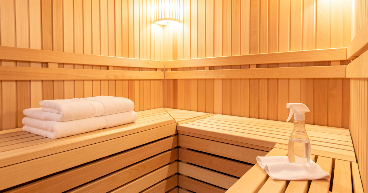 Clean infrared sauna interior with fresh folded towels and a cloth on the benches