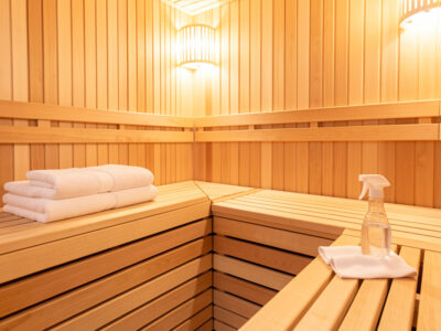 Clean infrared sauna interior with fresh folded towels and a cloth on the benches